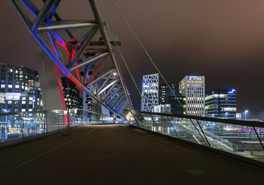 Oslo, Norway - 31 October 2015: View of the Akrobaten bridge at night with the illuminated modern skyscrapers of the Barcode Project in the background.