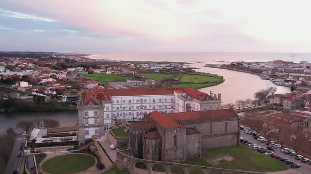 Aerial view of the historic Igreja e Mosteiro de Santa Clara with its red-tiled roofs overlooking the river and coastal town in Vila do Conde, Porto, Portugal.