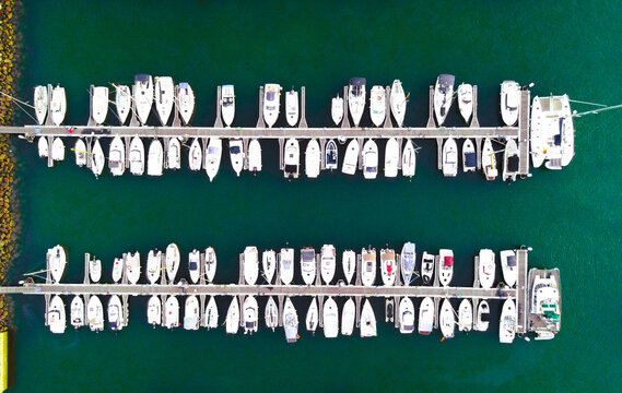 Aerial view of numerous white sailboats and yachts moored in orderly rows at a marina in Santa Cruz de Tenerife, Canary Islands, Spain.