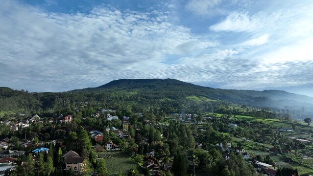 Aerial view of the town of Lembang nestled among lush green hills and agricultural fields in the mountainous landscape of West Java, Lembang, West Java, Indonesia.