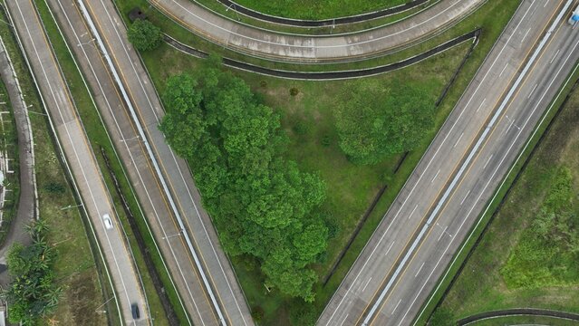 Aerial view of the Parungkuda highway interchange featuring multi-lane roads surrounded by lush green vegetation and trees in Parungkuda, West Java, Indonesia.