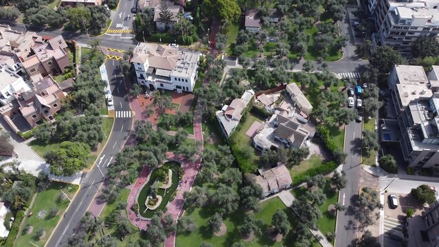 Aerial view of El Olivar Park featuring historic olive trees, walking paths, and a small pond surrounded by residential architecture in San Isidro, Lima Province, Peru.
