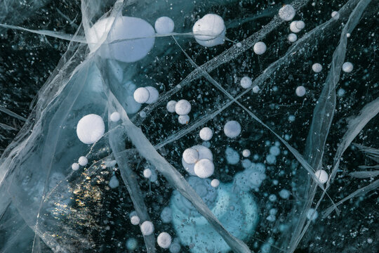 View of methane bubbles trapped in the thick frozen ice of Lake Baikal in Khuzhir, Irkutsk Oblast, Russia.