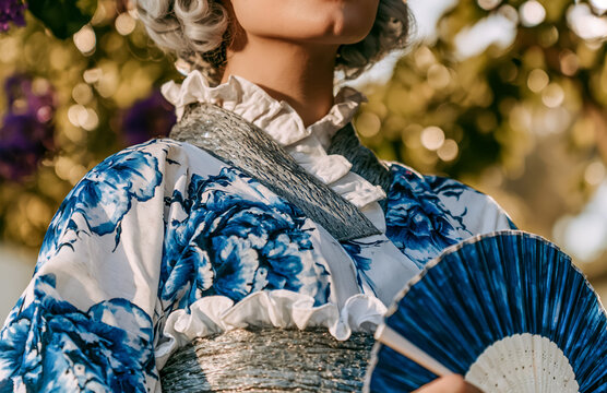 Yukata Kimono blue flower pattern, summer vibe, smiling woman of Japanese tradition with a cheerful portrait in a peaceful garden setting.