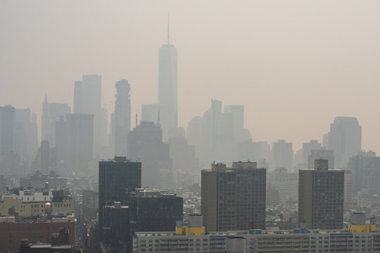 New York, United States - 16 July 2026: View of One World Trade Center rising above the hazy Manhattan skyline with dense urban buildings under a thick layer of wildfire smoke.
