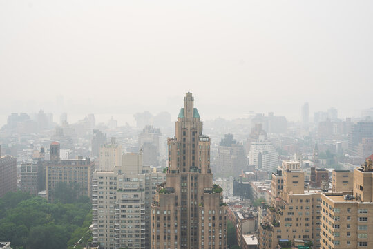 New York, United States - 16 July 2026: View of the iconic Art Deco skyscraper rising above the dense urban skyline of Manhattan under a hazy summer sky.
