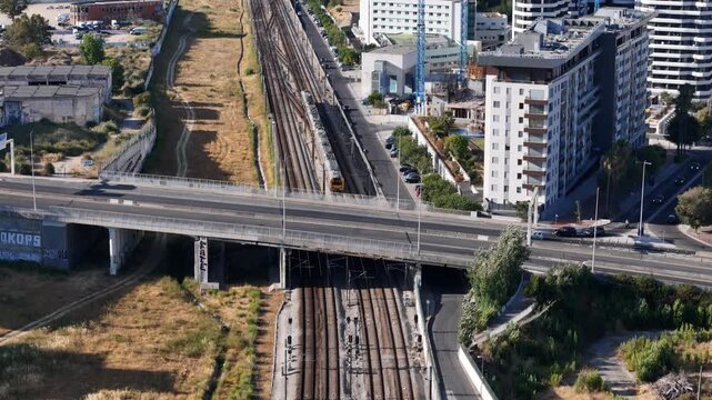 Aerial view of railway tracks passing under a highway bridge in Parque das Nacoes, Lisbon, Lisbon, Portugal.