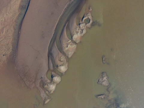 Aerial view of the coastline and sandbars at the river mouth in Kebumen, Central Java, Indonesia.
