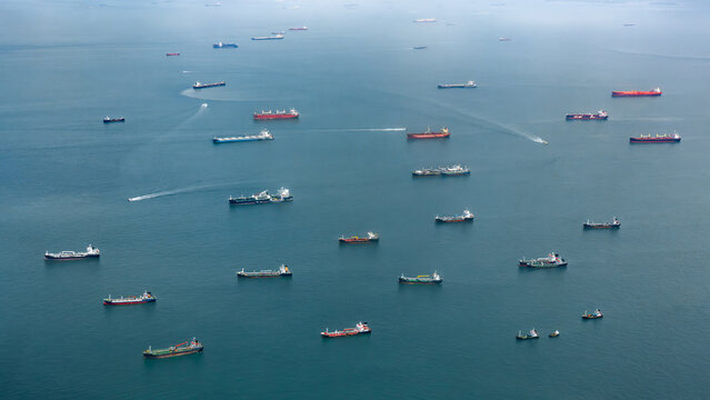 Aerial view of numerous cargo ships and oil tankers anchored in the busy waters of the Singapore Strait, Singapore, Singapore Strait, Singapore.