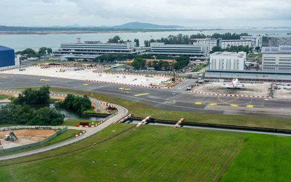 Singapore, Singapore - 17 June 2026: Aerial view of Singapore Changi Airport featuring airport infrastructure, runways, taxiways, and surrounding greenery under a cloudy sky.