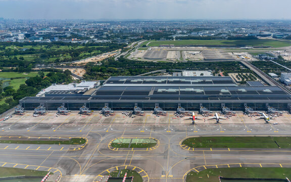 Singapore, Singapore - 14 June 2026: Aerial view of Singapore Changi Airport terminal 4 with parked airplanes, boarding gates, taxiways, and green landscape under a clear sky.