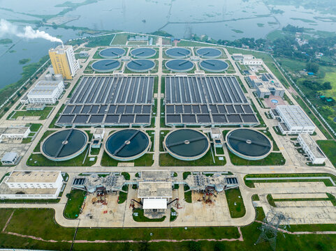 Aerial view of the Dasherkandi Sewage Treatment Plant in Aftab Nagar with large circular sedimentation tanks and rectangular basins in Dhaka, Dhaka Division, Bangladesh.