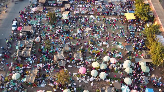 Aerial view of a bustling outdoor market in Kimana with numerous stalls, vendors, and shoppers gathered under the sun in Kimana, Kajiado County, Kenya.