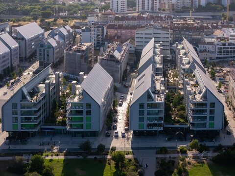 Aerial view of the modern Braco de Prata residential complex featuring distinctive pitched roofs, lush green courtyards, and contemporary architecture in Lisboa, Lisboa, Portugal.