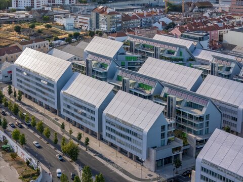 Aerial view of the modern Braco de Prata residential development featuring distinctive sloped roofs with solar panels and balconies in Lisboa, Lisboa, Portugal.
