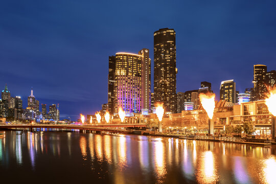 View of Crown Towers Melbourne illuminated at night with fire towers erupting along the Yarra River in Southbank, Victoria, Australia.