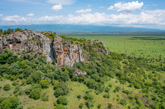Aerial view of the rocky cliffs and lush savanna landscape of Pian Upe Game Reserve in Moroto, Northern Region, Uganda.
