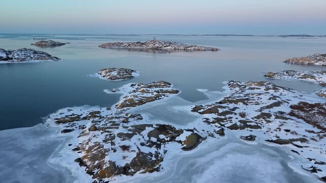 Aerial view of Stora Amundon covered in snow and ice with frozen coastal waters in Hovas, Vastra Gotalands lan, Sweden.