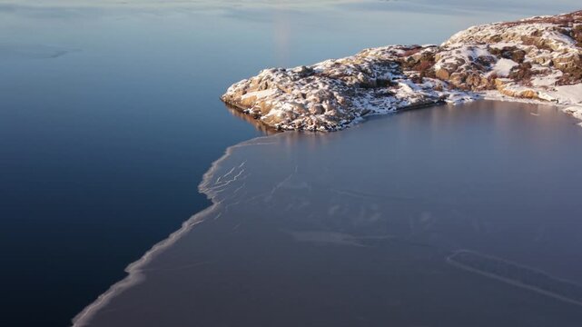 Aerial view of Stora Amundon showing icy coastal waters and rocky shoreline in Hovas, Vastra Gotalands lan, Sweden.