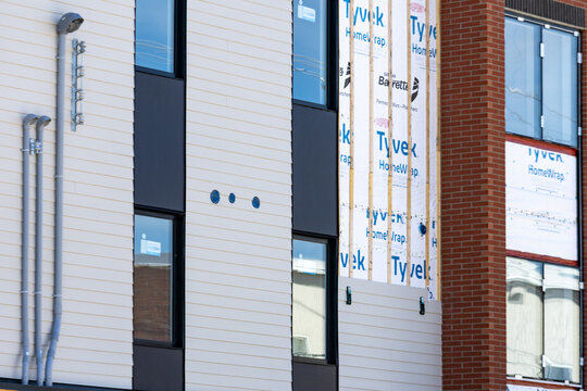 La Tuque, Quebec, 23 May 2026 : Exterior view of a building under construction featuring Tyvek HomeWrap, siding, and brick facade