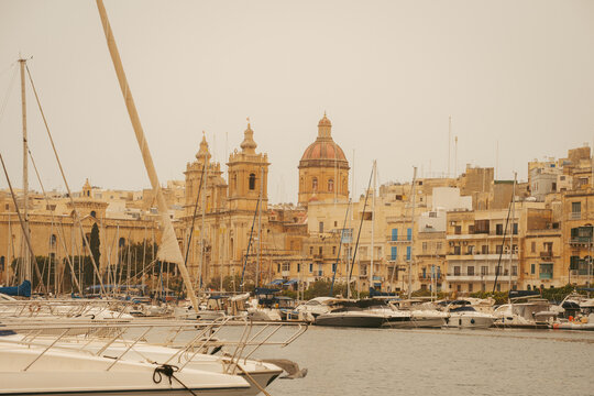 Senglea, Malta - 15 July 2022: View of the Basilica of Our Lady of Victories with yachts moored in the Grand Harbour.