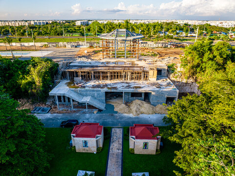 Aerial view of the Casa Arquidiocesana Maria de La Altagracia construction site, featuring concrete framing and lush green trees in Santo Domingo Este, Santo Domingo Provinc, Dominican Republic.