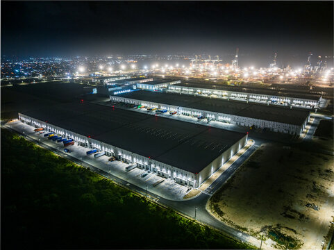 Aerial view of the illuminated Caucedo Logistics Center at night, featuring large warehouse facilities and shipping containers in Andres, Santo Domingo, Dominican Republic.