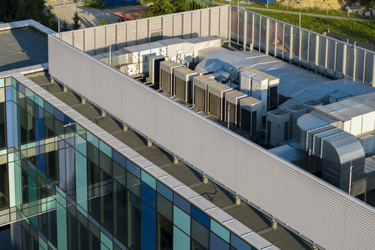 Aerial view of the rooftop of an AI data center featuring multiple HVAC units and ventilation systems on a modern building with a glass facade in Krakow, Lesser Poland Voivode, Poland.