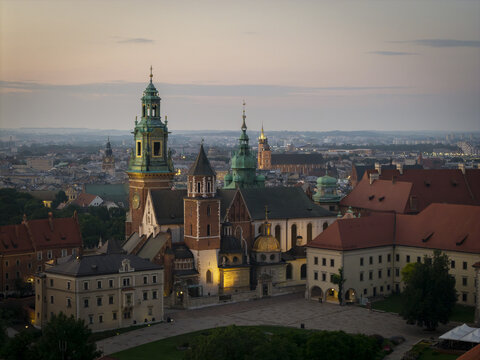 Aerial view of Wawel Royal Castle with its historic towers, domes, and red-tiled roofs, set against the urban skyline of Krakow, Lesser Poland Voivode, Poland.