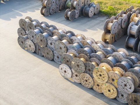 Krakow, Poland - 18 July 2026: Aerial view of Tele-Fonika Kable industrial site featuring numerous large wooden cable spools arranged in rows on a paved yard.