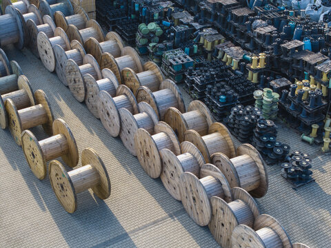 Krakow, Poland - 18 July 2026: Aerial view of Tele-Fonika Kable featuring rows of large wooden cable reels and industrial equipment stored in an outdoor yard.