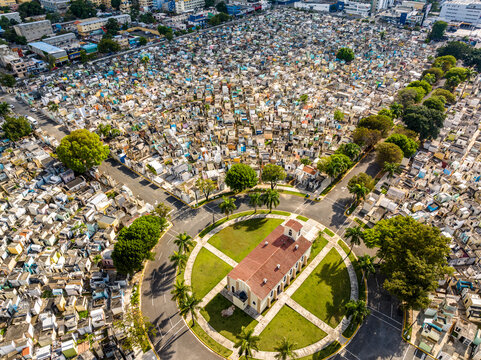 Aerial view of Maximo Gomez National Cemetery with dense rows of tombs, pathways, and a central chapel surrounded by palm trees in Santo Domingo, Distrito Nacional, Dominican Republic.