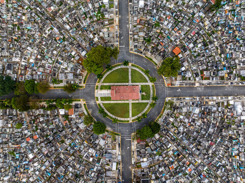 Aerial view of the circular layout of Maximo Gomez National Cemetery with its central building, dense rows of graves, and greenery in Santo Domingo, Distrito Nacional, Dominican Republic.