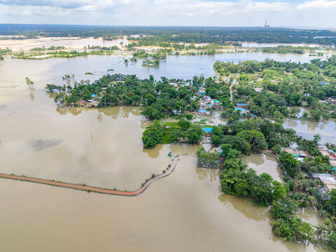 Aerial view of flooded residential areas and lush vegetation surrounded by extensive floodwaters in Banshkhali Upazila, Chittagong Division, Bangladesh.