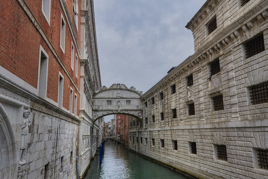 Venice, Veneto, Italy - 06 May 2022: View of the historic Bridge of Sighs spanning the canal between the Doge's Palace and the prison, with ornate stone architecture and barred windows.