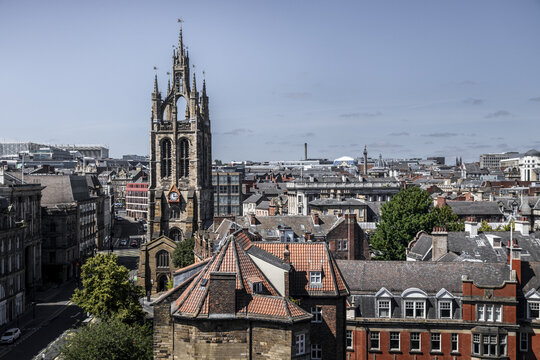 Aerial view of St. Nicholas Cathedral surrounded by historic red-tiled rooftops and urban architecture in Newcastle upon Tyne, England, United Kingdom.