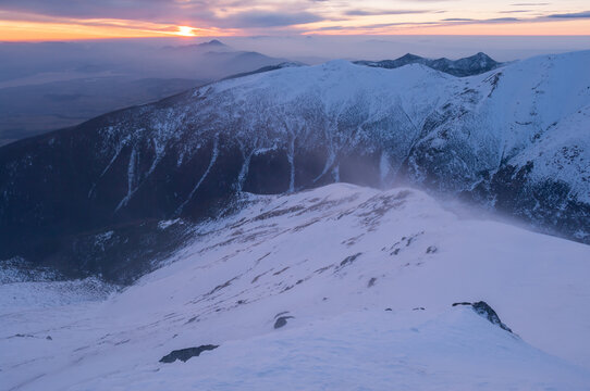 View of Baranec peak in the Western Tatras during a strong winter wind at sunset, with snow-covered slopes and dramatic light in Jamnik, Zilina Region, Slovakia.
