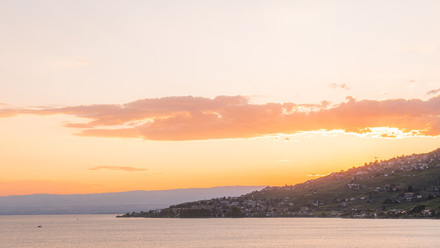 View of the terraced vineyards of the Lavaux region overlooking Lake Geneva at sunset in Bourg-en-Lavaux, Vaud, Switzerland.