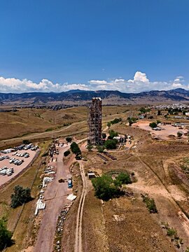 Aerial view of the historic Leyden coal mine tipple structure surrounded by arid landscape, dirt roads, and distant mountains in Jefferson County, Colorado, United States.