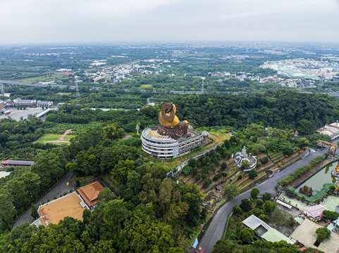 Aerial view of the Fo Guang Shan Buddha Museum featuring the giant golden Buddha statue surrounded by lush green hills and temple grounds in Jiuru Township, Pingtung County, Taiwan.