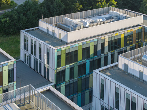 Aerial view of the ai data center cooling system on the rooftop of a modern building with colorful glass panels in Krakow, Lesser Poland Voivode, Poland.