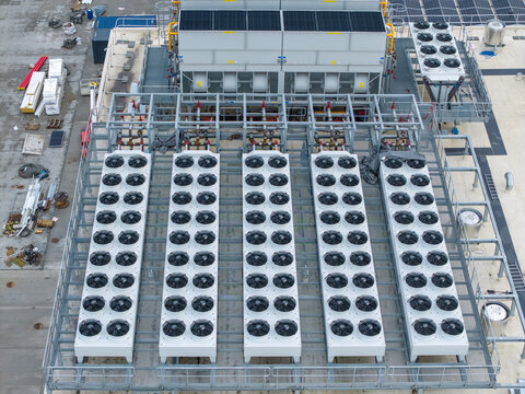 Aerial view of an AI data center cooling system with rows of industrial fans and metal piping on a rooftop in Krakow, Lesser Poland Voivode, Poland.