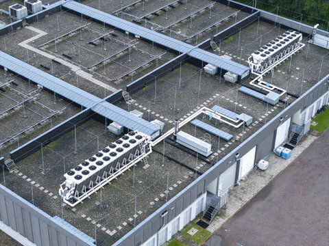 Aerial view of an AI data center cooling system with industrial chillers and piping installed on a flat roof in Krakow, Lesser Poland Voivode, Poland.
