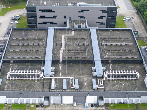 Aerial view of the ai data center cooling system with industrial HVAC units, ventilation fans, and piping networks on the roof of a modern facility in Krakow, Lesser Poland Voivode, Poland.