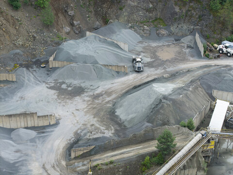Aerial view of the porphyry and diabase mine featuring large piles of crushed stone, industrial machinery, and conveyor systems in Krakow, Lesser Poland, Poland.