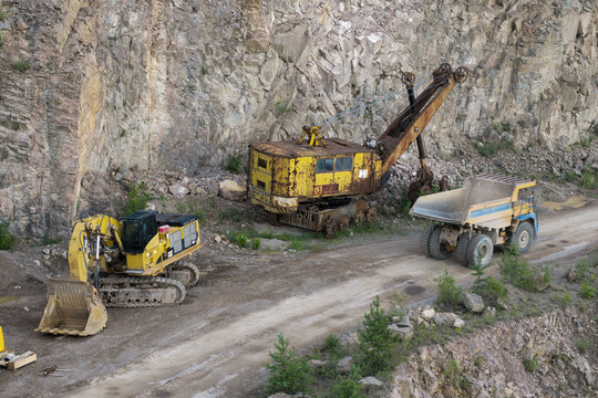 Aerial view of heavy machinery including a yellow excavator and a vintage shovel working in the Porphyry and diabase mine in Krakow, Lesser Poland Voivode, Poland.