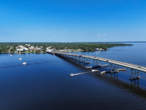 Boats passing under the Memorial Bridge on the St Johns River with historic downtown Palatka in the background in Putnam County, Florida. 