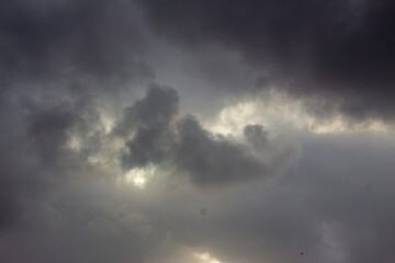 Obraz premium Dramatic Dark Storm Clouds with Sunlight Breaking Through, Moody Sky and Powerful Weather Background