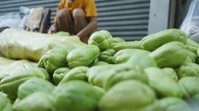 Vendor Removing and Arranging Chayote from a Sack at a Local Market
