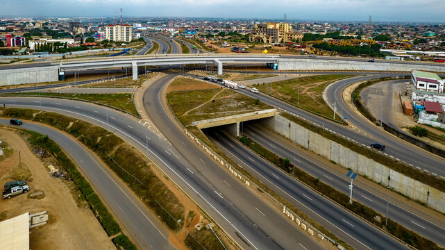 Aerial view of Tema Motorway interchange featuring multi-level highway roads, concrete overpasses, and surrounding urban development in Accra, Greater Accra Region, Ghana.